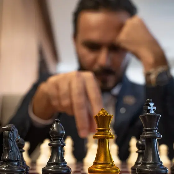 A hand moving a gold chess piece